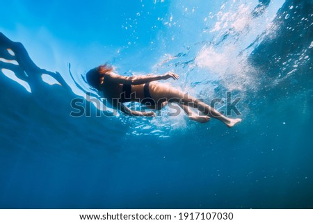 Young woman in bikini floating in blue sea. Activity summer days at sea