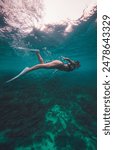 A young woman in a bikini and snorkel suit swimming in Cebu, Philippines