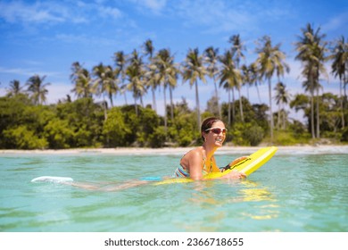 Young woman in bikini surfing on tropical beach in Asia. Girl on surf board on ocean wave. Active water sports for toned fit body. Female athlete swimming. Surfer in exotic sea. Swim and eye wear.


 - Powered by Shutterstock