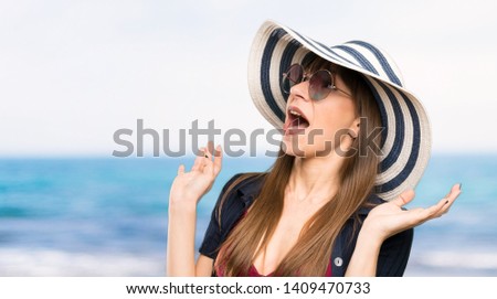 Young woman in bikini with surprise facial expression at the beach