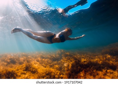 Young woman in bikini swimming and dive underwater in blue sea. Activity summer days at sea