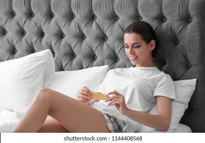 Young woman with birth control pills in bedroom. Gynecology