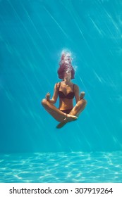 Young Woman In Black Bikini In Yoga Position Underwater In Diving Aquarium, Full Body Shot, Front View Through The Glass