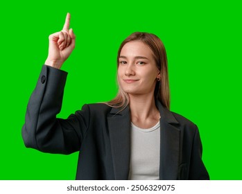 Young Woman in Black Blazer Points Upward Against Green Screen - Powered by Shutterstock