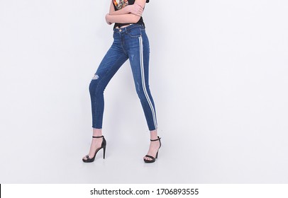 Young woman in black shirts with Legs in blue striped jeans with black high hell shoes posing in studio