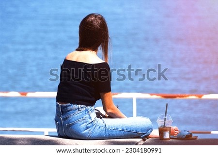 Young woman in black top and jeans relaxing