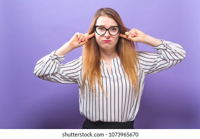 Young Woman Blocking Her Ears On A Solid Background