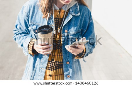 Young woman blogger texting on her phone on the street