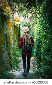 A Young Woman With Blond Dreadlocks, Back View, Goes Through The Greens. Adventure.