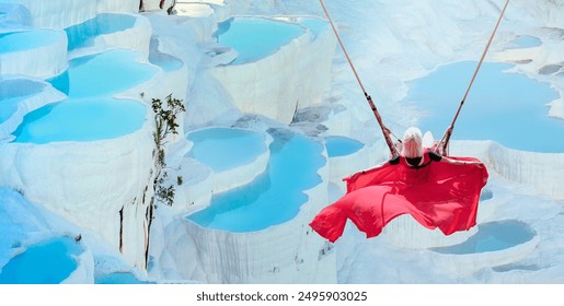 A young woman with blond hair is swaying on swing over Natural travertine pools and terraces in Pamukkale. Cotton castle in southwestern Turkey - Powered by Shutterstock