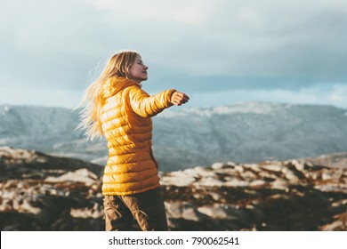 Young Woman blonde enjoying mountains landscape Travel Lifestyle happy emotions concept adventure outdoor active vacations in Norway girl tourist walking wearing yellow down jacket - Powered by Shutterstock