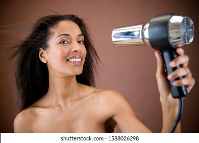 A Young Woman Blow Drying Her Hair