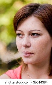 Young Woman Blowing Smoke In The Air