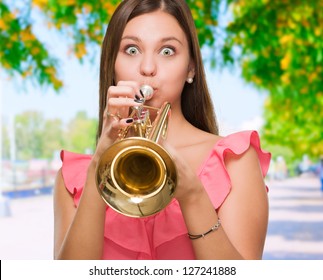 Young Woman Blowing Trumpet, outdoor