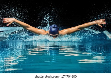 Young Woman In Blue Cap And Swimming Suit In Pool