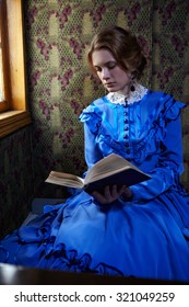 Young Woman In Blue Vintage Dress Late 19th Century Reading The Book In Coupe Of Retro Train