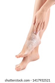 Young woman with body scrub on her legs against white background
