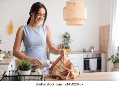 Young Woman With Bottle And Eco Bag In Kitchen