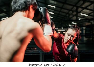 Young Woman Boxer Doing Exercise Punching Competing With Man Opponent At Boxing Camp