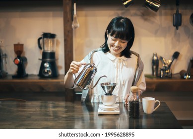 A Young Woman Brewing Coffee In A Fashionable Space