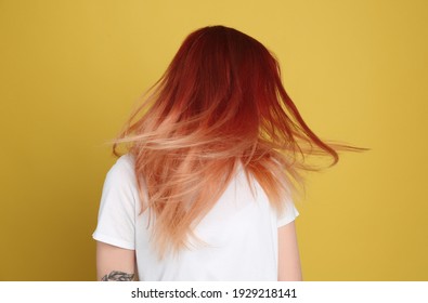 Young woman and bright dyed hair yellow background