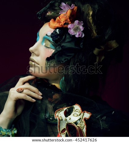 Young woman with bright make up with carnaval mask
