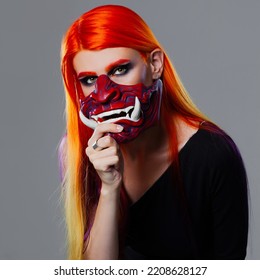 Young Woman With Bright Orange Hair In Asian Demon Mask, Futuristic Cyber Punk Style, Close-up