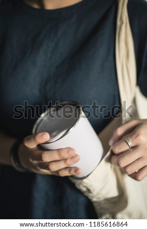 Young woman bringing and taking out tumbler, reusable coffee mug/cup from her bag.
 Stock photo © 