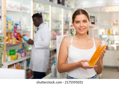 Young Woman With Brown Hair Electing Haircare Shampoo In Drugstore