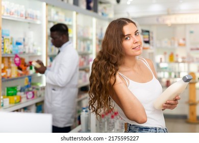 Young Woman With Brown Hair Electing Haircare Shampoo In Drugstore