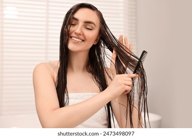 Young woman brushing hair after applying mask in bathroom - Powered by Shutterstock