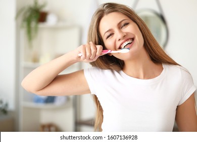 Young Woman Brushing Teeth At Home