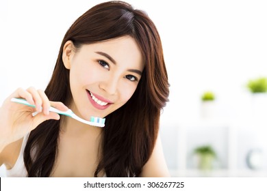 Young Woman  Brushing Teeth In The Morning