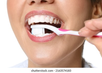 Young Woman Brushing Teeth With Paste On White Background, Closeup