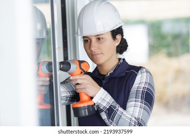 Young Woman Builder Using Power Drill At Home