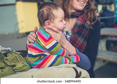 A Young Woman Is Burping Her Baby Outside