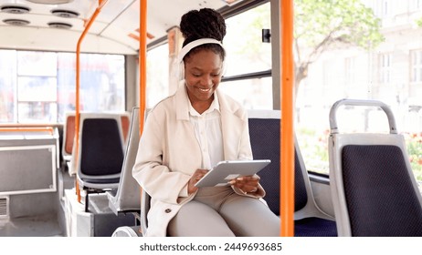 Young woman in the bus playing music on a tablet - Powered by Shutterstock