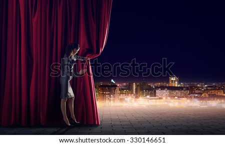 Young woman in business suit opening color curtain of stage