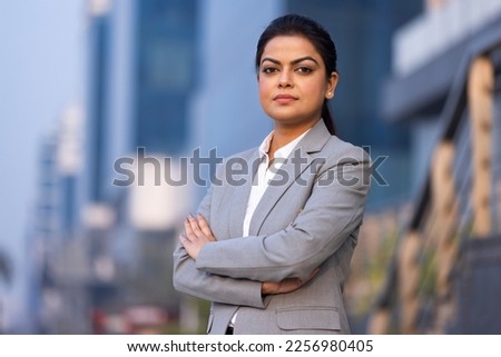 Young woman in business wear standing with armes crossed in business environment,
