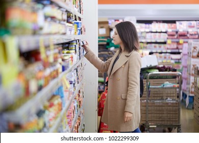 Young Woman Buy Can Of Tuna At Supermarket