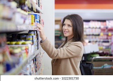 Young Woman Buy Can Of Tuna At Supermarket