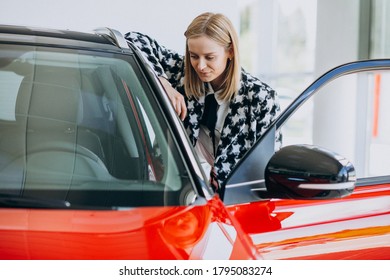 Young Woman Buying A Car In A Car Showroom