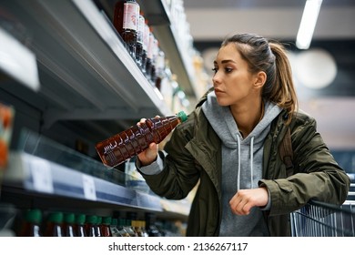 Young Woman Buying Cooking Oil And Taking The Last Bottle From Product Shelf In Grocery Store.