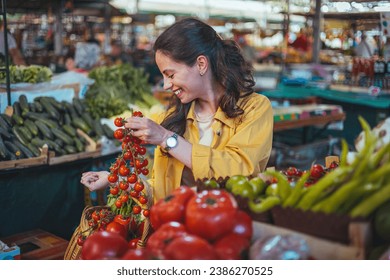 Young woman buying fresh vegetables on the market. Young Female Looking For Some Vegetables At Market Place. Young woman at the market. Only organic. Fresh from the earth.  - Powered by Shutterstock