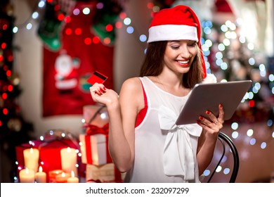 Young Woman Buying Gifts With Credit Card On Christmas At Home