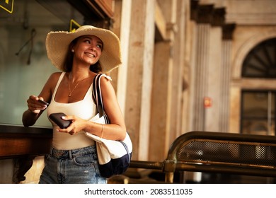 Young woman buying a ticket for train with a credit card. Beautiful woman going to a trip	