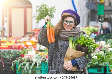 Young Woman Buying Vegetables At Local Market