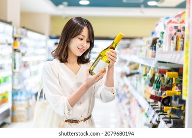 Young Woman Buying Wine At Store