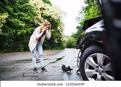 Young Woman By The Damaged Car After A Car Accident, Making A Phone Call.