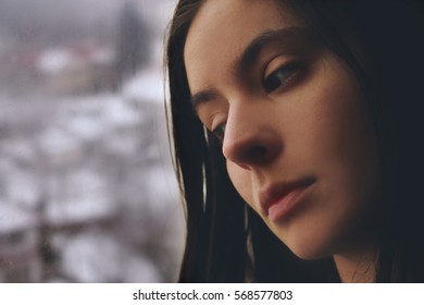 Young Woman By The Window Sad And Alone